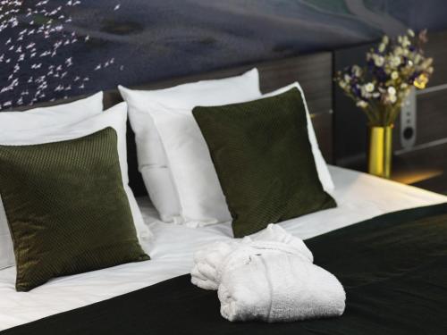 a white towel is laying on a bed with pillows at Novotel Paris Porte Versailles in Paris