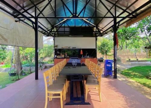 a patio with a table and chairs under a roof at Mộc Hoa Viên Homestay in Ấp Thiện Lập