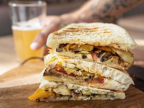 a sandwich cut in half with a glass of beer at Novotel Paris Porte Versailles in Paris