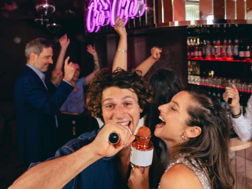 a man feeding a woman a microphone at a bar at Novotel Paris Porte Versailles in Paris
