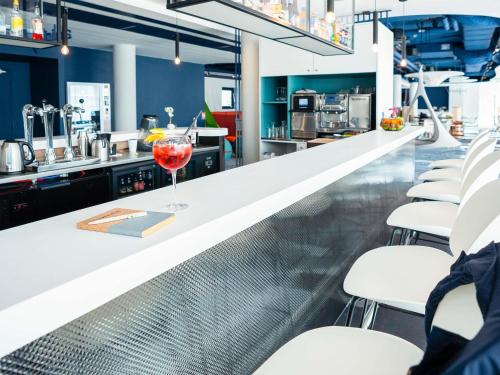 a bar with a glass of wine on a counter at ibis Styles Paris Orly Airport in Paray-Vieille-Poste