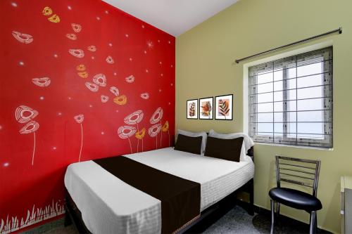 a bedroom with a bed and a red wall at Hotel O Star Light Guest House in Hyderabad