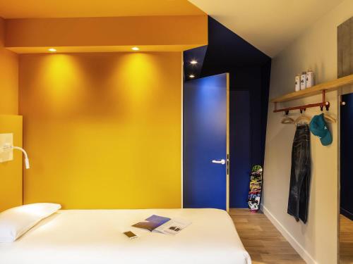 a room with two beds and a blue door at Ibis Budget Montpellier Nord Euromédecine in Montpellier