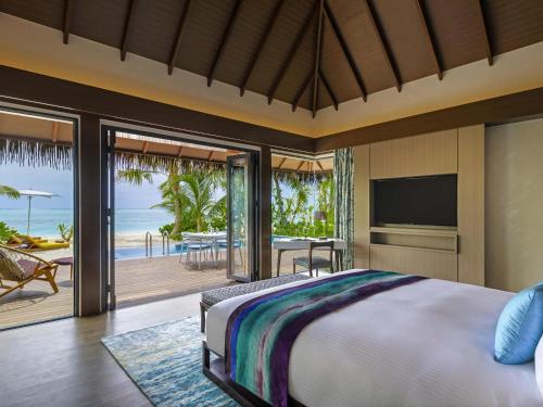 a bedroom with a bed and a view of the ocean at Pullman Maldives Maamutaa - All-Inclusive Resort - 50 percent off Transfers in Maamutaa