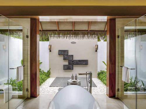 a bathroom with a bath tub in a room at Pullman Maldives Maamutaa - All-Inclusive Resort - 50 percent off Transfers in Maamutaa