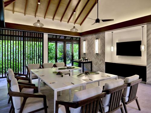 a dining room with a table and chairs and a television at Pullman Maldives Maamutaa - All-Inclusive Resort - 50 percent off Transfers in Maamutaa