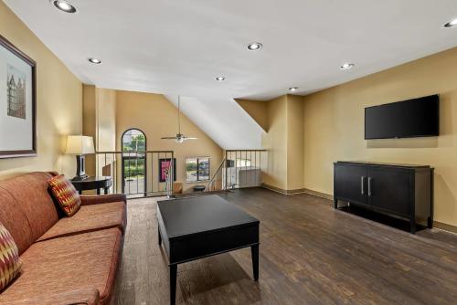 a living room with a couch and a flat screen tv at Suburban Studios Brentwood - Nashville in Brentwood