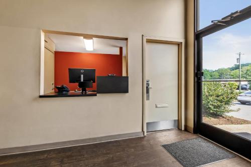 a room with a door and a tv on the wall at Suburban Studios Brentwood - Nashville in Brentwood