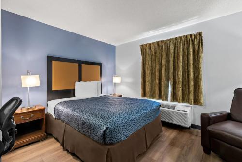 una camera da letto con un letto, una sedia e una finestra di Suburban Studios Brentwood - Nashville a Brentwood