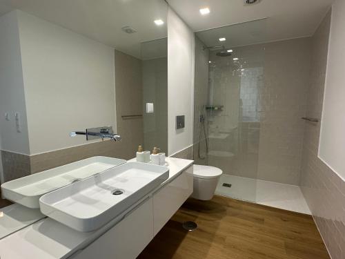 un bagno bianco con lavandino e WC di WHome Cozy Riverside Apartment in Trafaria a Trafaria