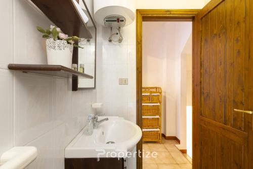 a bathroom with a sink and a wooden door at Il terrazzo sulla duna 4 Torre dei Corsari in Torre Dei Corsari