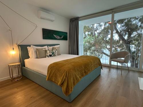 una camera da letto con un letto e una grande finestra di WHome Cozy Riverside Apartment in Trafaria a Trafaria