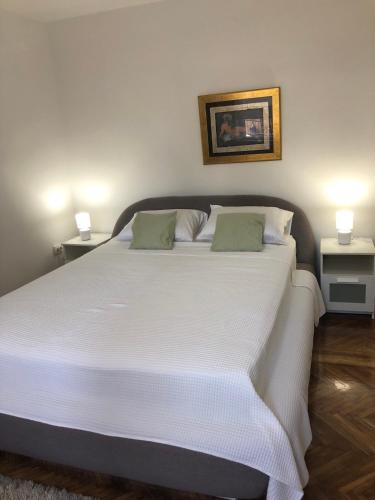 a bedroom with a large white bed with two lamps at Lea in Križevci