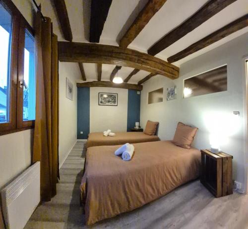 a bedroom with two beds in a room with wooden ceilings at Maison plein centre in Brain-sur-Allonnes
