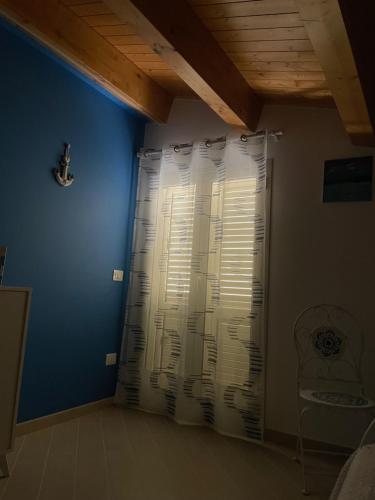 a room with a blue wall and a shower curtain at Villa Marinella in Granelli