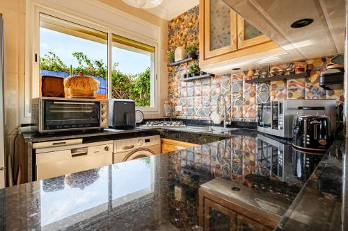 a kitchen with a granite counter top and a window at 4 min à pied de la Plage, 3 BR, Piscine, Parking in Skhirat