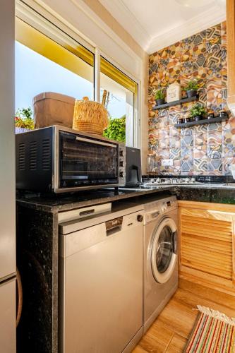 a kitchen with a microwave and a washing machine at 4 min à pied de la Plage, 3 BR, Piscine, Parking in Skhirat