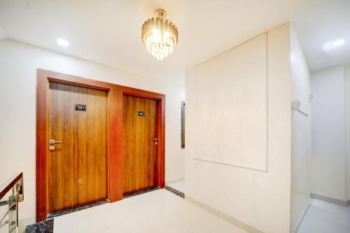 a hallway with a wooden door and a chandelier at Hotel O Shri Vinayak in Shamsgarh