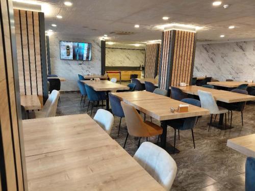 a dining room with wooden tables and chairs at QUEEN PALACE HOTEL TRABZON in Trabzon