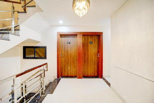 a hallway with a wooden door and a chandelier at Hotel O Shri Vinayak in Shamsgarh