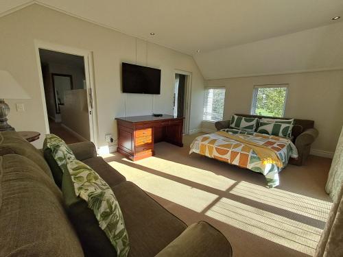a living room with a bed and a television at Wild Mushroom Country House in Stellenbosch