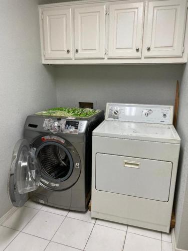 a washing machine and a washer in a kitchen at Homestayyy in Dallas