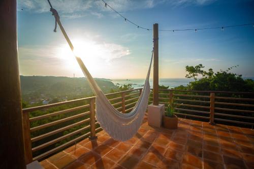 a hammock on a balcony with a view of the ocean at Ocean Views Amazing Rooftop in Mazunte