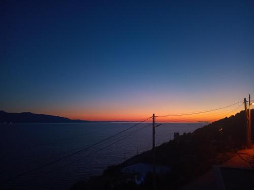 a view of the ocean at sunset at Villa Besnik in Sarandë