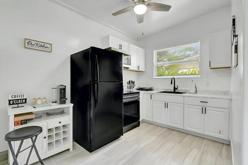 a black refrigerator in a kitchen with white cabinets at Fort Lauderdale Home near Nightlife and Beach in Fort Lauderdale