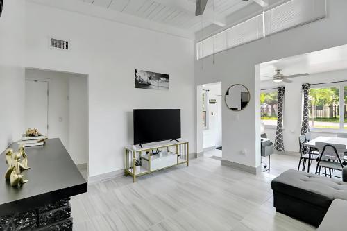 a white living room with a tv and a couch at Fort Lauderdale Home near Nightlife and Beach in Fort Lauderdale
