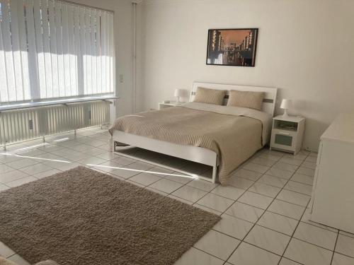 a bedroom with a large bed and a rug at Apartment with Garden in Norderstedt county Hamburg, near Metro in Norderstedt