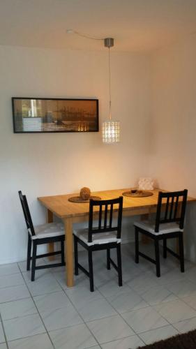 a dining room table with two chairs and a table and a light at Apartment with Garden in Norderstedt county Hamburg, near Metro in Norderstedt