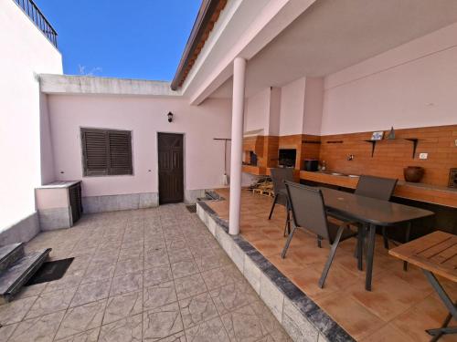 Un patio con una mesa y sillas en un edificio. en Constança House, en Corroios