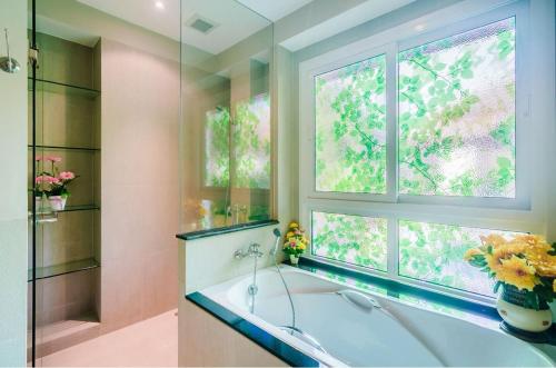a bathroom with a bath tub and a window at 4 bedroom Villa with Private pool at Laguna in Angsana in Ban Thalat Choeng Thale