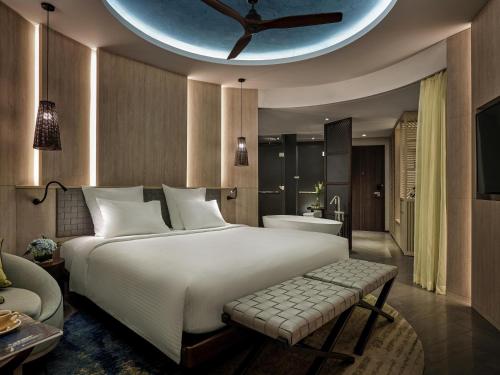 a bedroom with a large bed and a bathroom at Pullman Phu Quoc Beach Resort in Phu Quoc
