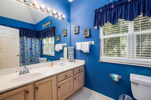 a blue bathroom with a sink and a toilet at 23 Davis Love in Fripp Island