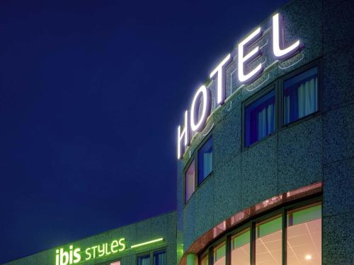 a lit up sign on the side of a building at ibis Styles Almere in Almere