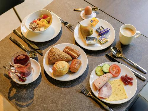 a table with plates of breakfast foods and a cup of coffee at ibis Styles Almere in Almere