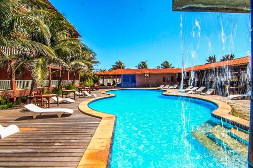a swimming pool with chairs and a wooden deck at Porto Futuro Hotel in Fortaleza