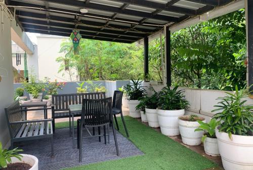 a patio with a table and chairs and potted plants at Home Away From Home in Kolhapur