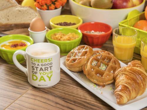 a table with a plate of pastries and a cup of coffee at ibis Styles Almere in Almere