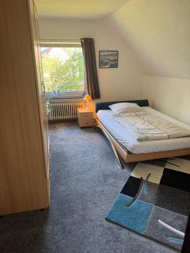 a small bedroom with a bed and a window at Ferienhaus Wiegboldsbur in Südbrookmerland