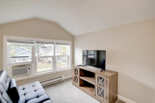 a living room with a couch and a tv and two windows at Walk to WKU, Bars and Dining! Updated Duplex Home in Bowling Green