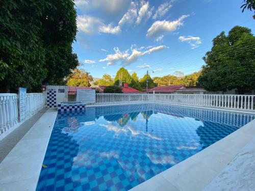 a swimming pool with a white fence and blue at Casa Acaritama 4 in Melgar