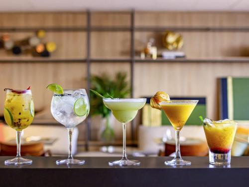 a group of four cocktails sitting on a table at Mercure Itajai Navegantes in Itajaí