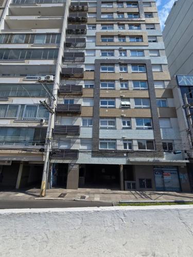 a tall building with a street light in front of it at Apartamento Novo e com garagem em frente ao parque da Redenção em Porto Alegre in Porto Alegre