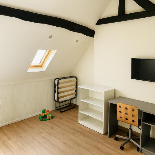 a attic room with a desk and a chair at Villa Petit Charles - CDG Paris airport - Parc Asterix - Extra Shuttle in Le Mesnil-Amelot