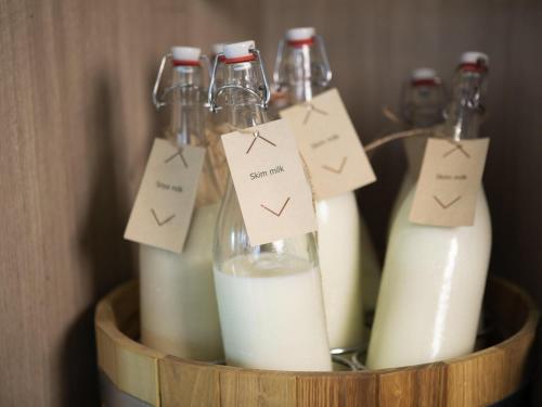 a group of bottles of milk in a wooden container at Mercure Bangkok Sukhumvit 24 in Bangkok