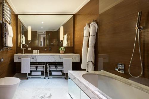 a bathroom with a tub and a large mirror at Nobu Hotel Roma in Rome