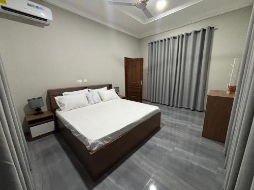 une chambre avec un grand lit et une fenêtre dans l'établissement Explore Afreeka Serviced Apartments Abia Beach, à Trofwi